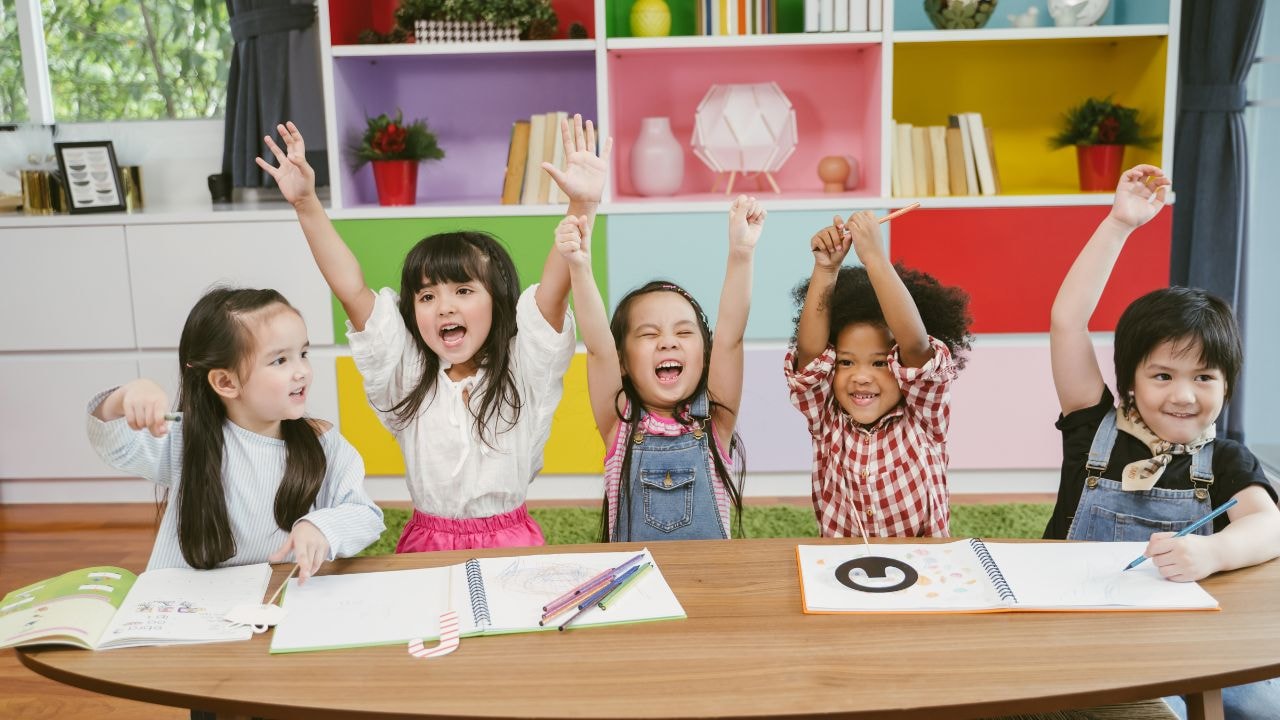 Happy children engaging in indoor activities like writing and drawing at an afterschool care.