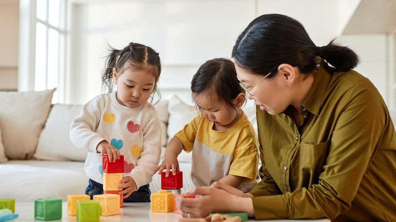 Young children using blocks with their teacher, promoting holistic early childhood development